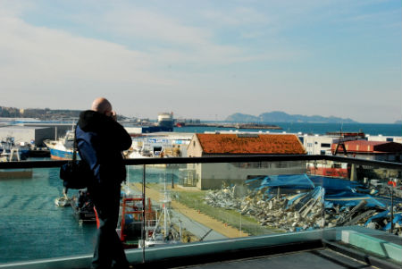 Uno de los cruceristas del Ariadna sacando fotos de los cascotes de la Nave de Cableros