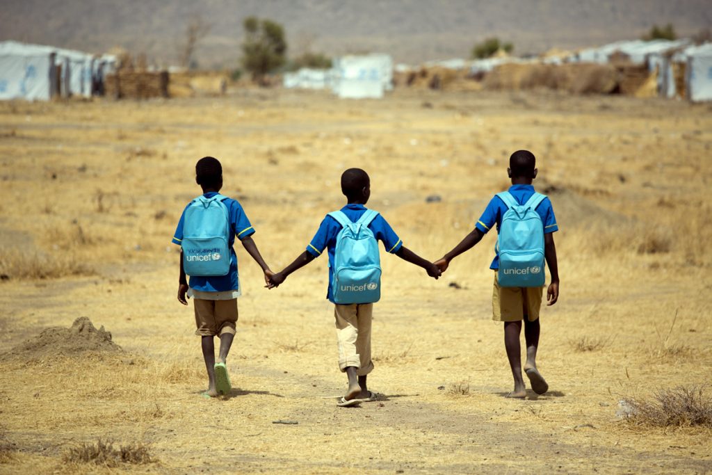 Children walk home after school at the Minawao refugee camp in Northern Cameroon, Tuesday 5 April 2016. The conflict in North-East Nigeria prompted by Boko Haram has led to widespread displacement, violations of international humanitarian and human rights law, protection risks and a severe humanitarian crisis. This is one of the fastest growing displacement crisis in Africa – one of the world’s most forgotten emergencies, with little attention from the donor community. Across Nigeria, Niger, Cameroon and Chad, over 2.7 million people – mostly women and children – have now fled the Boko Haram-related violence. Many children have been subject to grave violations including forced recruitment, and being used as suicide bombers. Women and girls have been trafficked, raped, abducted and forcibly married. Schools have been attacked, looted, damaged or used as shelter by displaced families. The conflict is exacting a heavy toll on children, affecting not just their well-being and their safety but also their access to basic health, education, nutrition and social services.