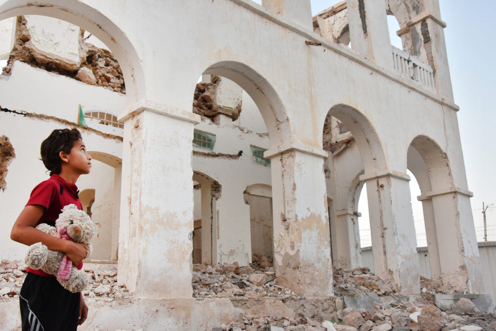 Photo was taken in Almukalla city in Southern Yemen. It shows a child looking at his destroyed house, carrying his toy which it was the only thing that he was able to rescue.