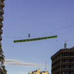 Una activista de Greenpeace camina sobre una cuerda a 30 metros de altura en pleno centro de Madrid