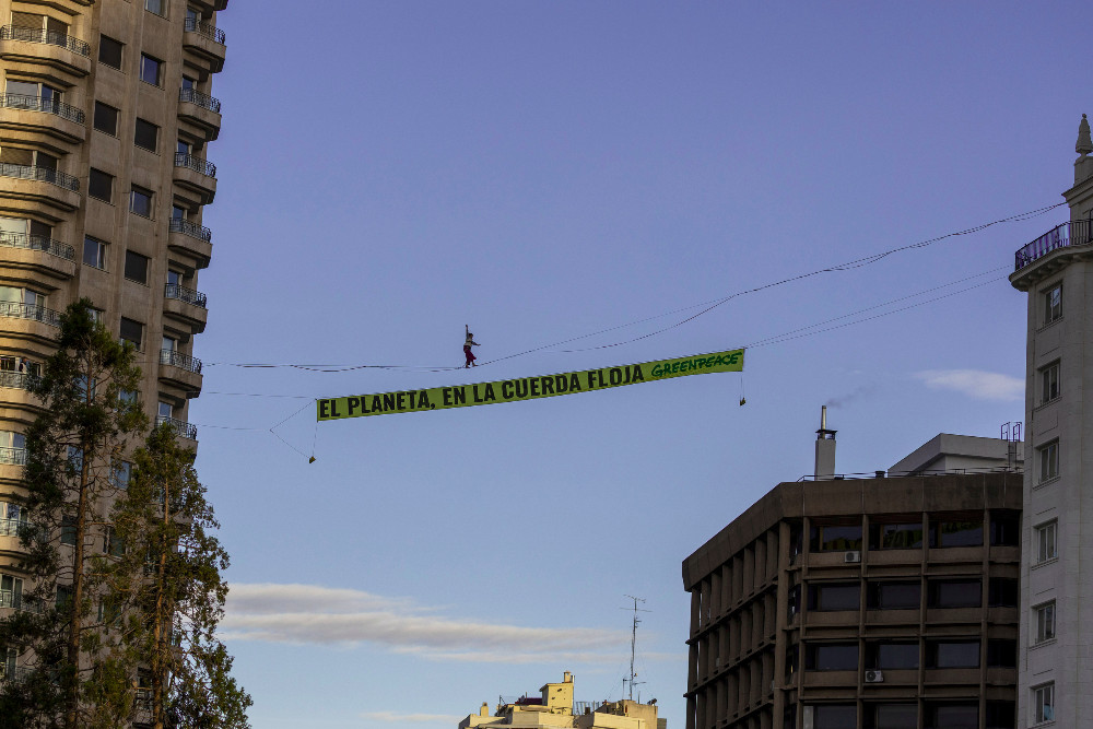 Una activista de Greenpeace camina sobre una cuerda a 30 metros de altura en pleno centro de Madrid 